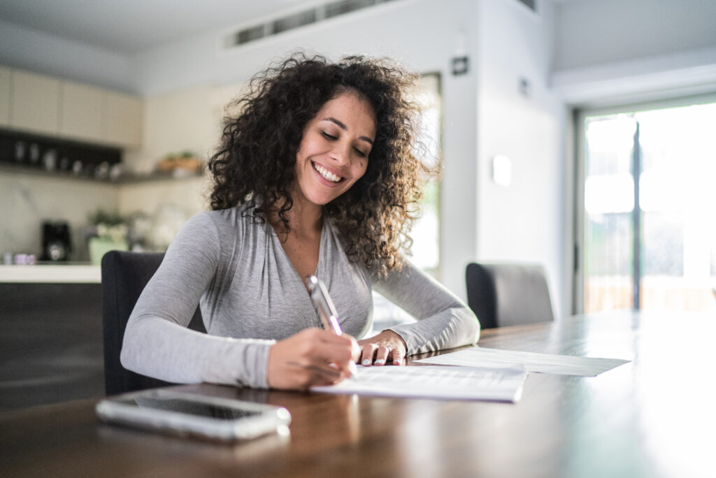 mid adult woman filling document at home